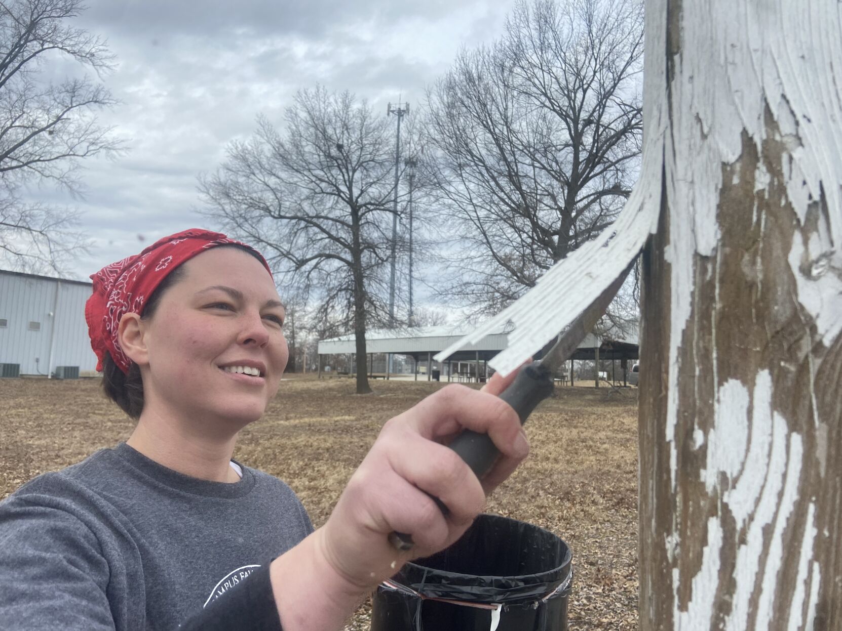 Nicole Muirhead chips away paint on rink sign